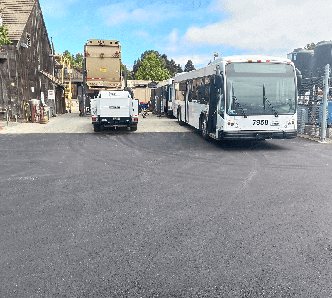 Bus and truck parked in industrial area.
