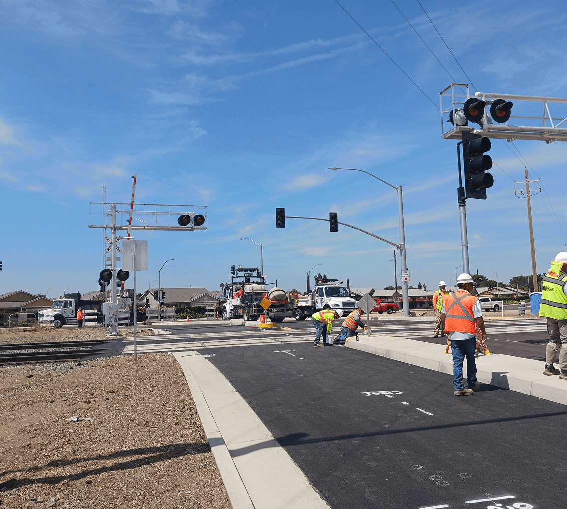 Road construction workers at railroad crossing site.