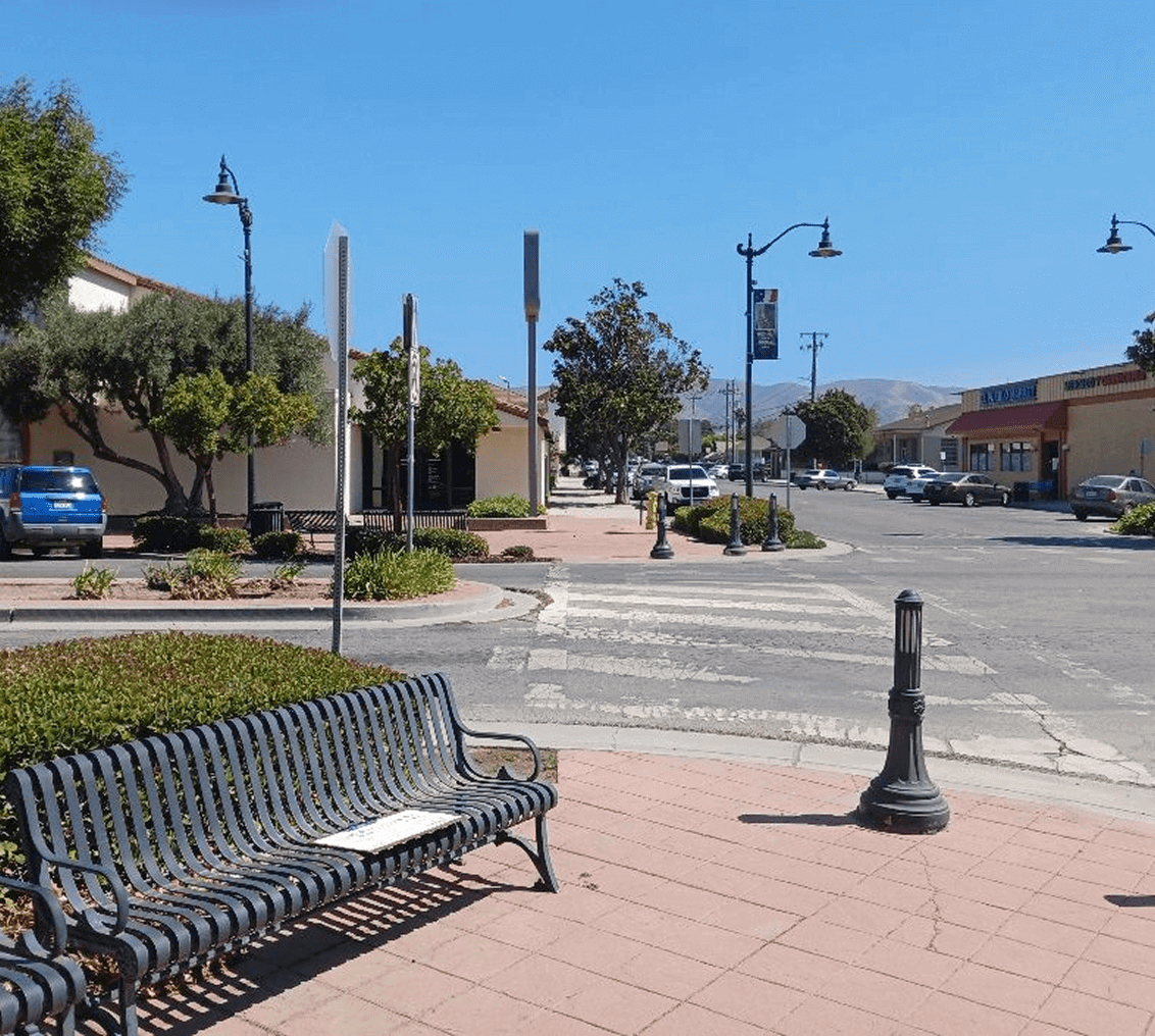 Quiet street with bench and streetlights.