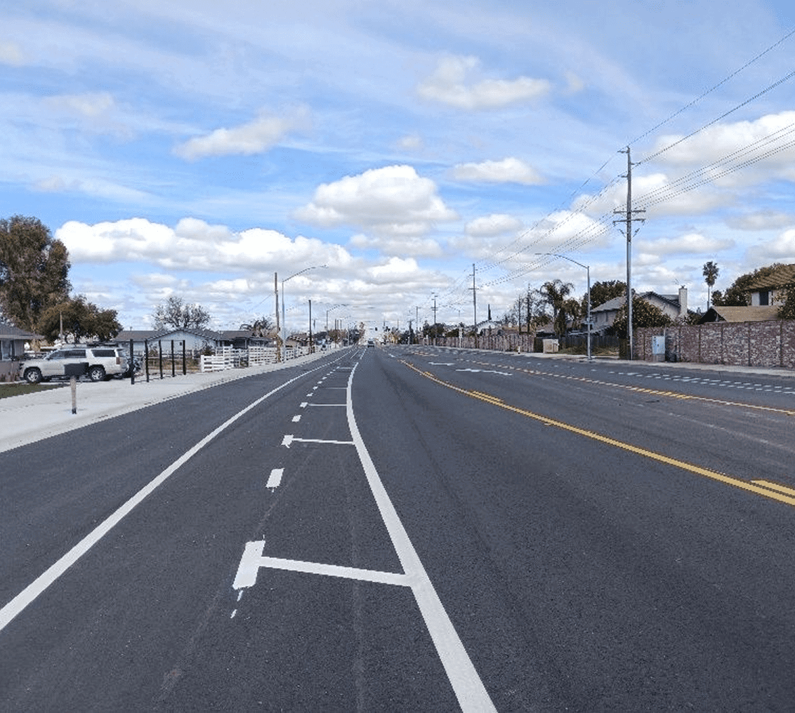 Empty road under a cloudy blue sky.