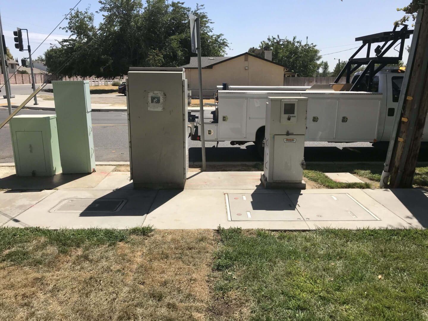 Utility boxes and truck on suburban street.